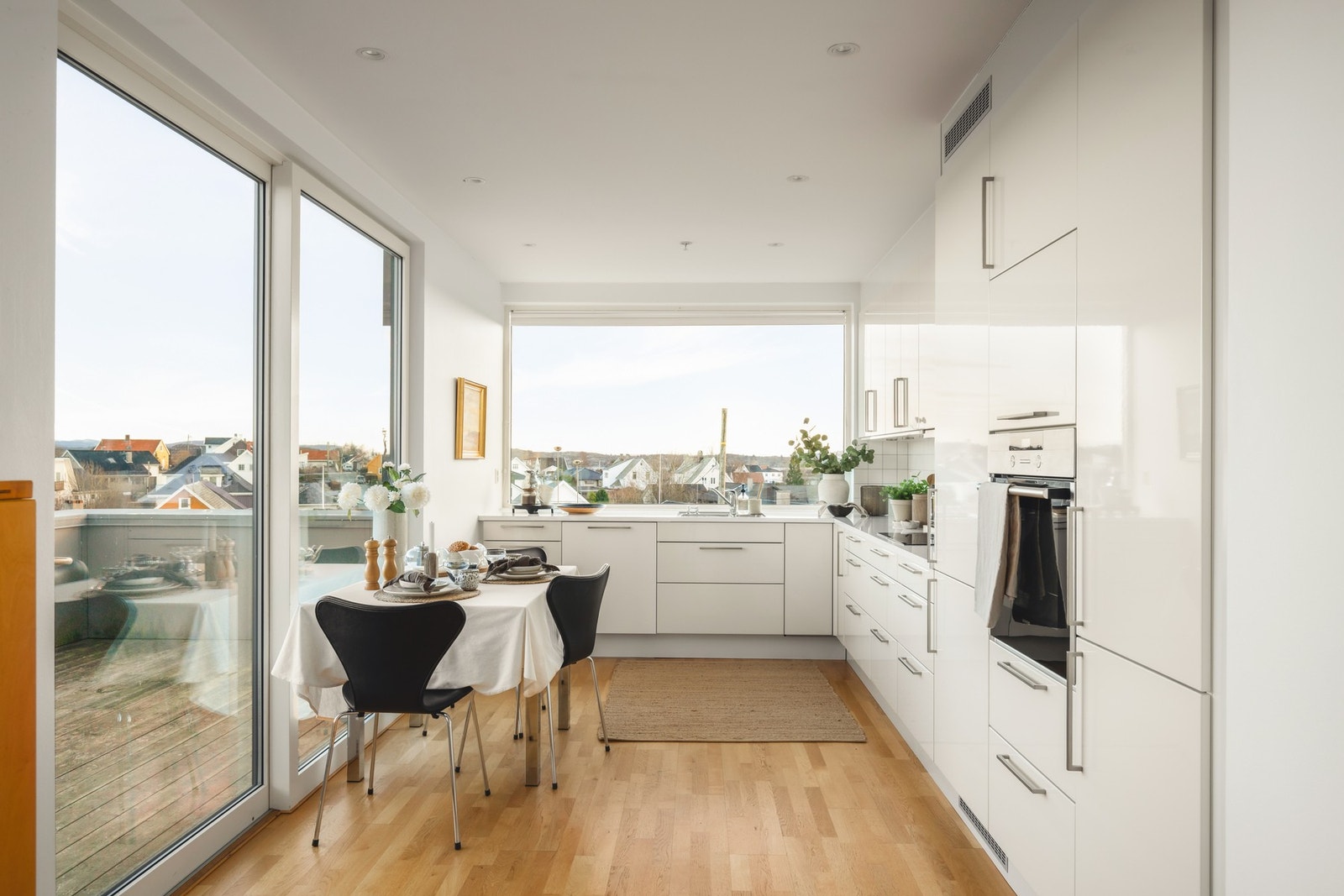 Innredet med glatte høyglans fronter og laminat benkeplate, levert av HTH Kjøkkenforum. Galleribilde