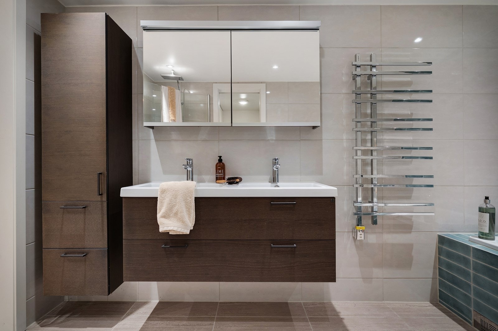 Baderomsinnredning med dobbelservant og baderomsskap med god lagringsplass Galleribilde