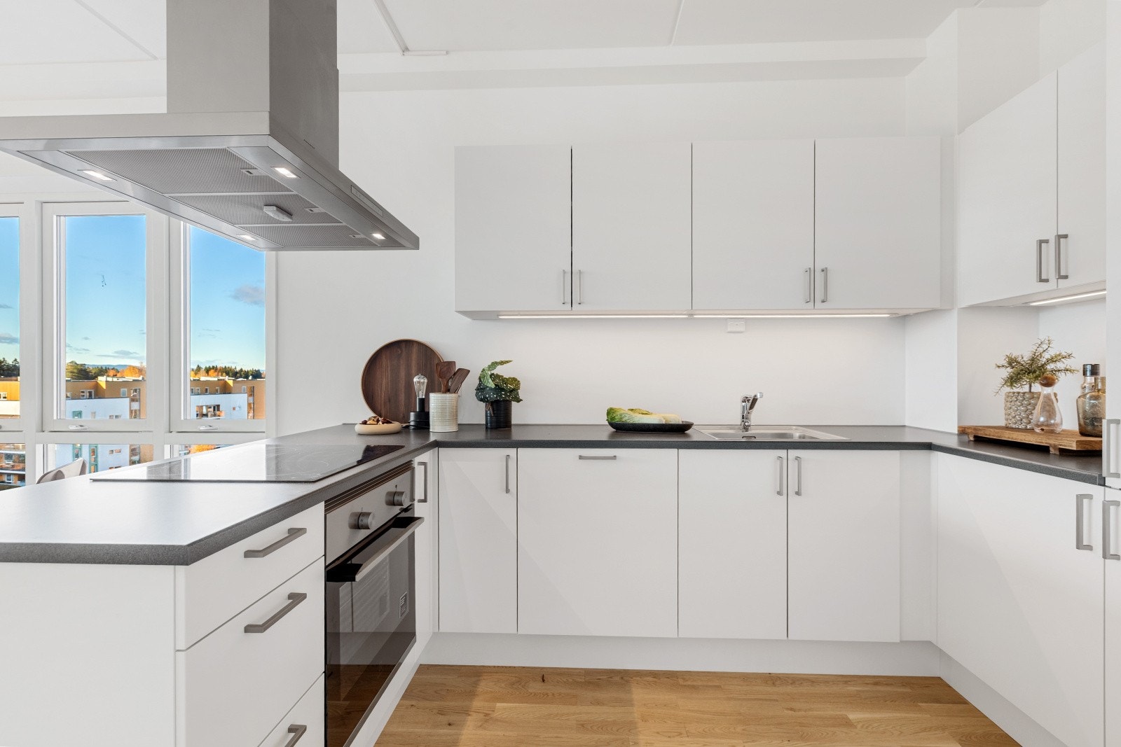 Sosialt kjøkken med platetopp vendt mot rommet Galleribilde