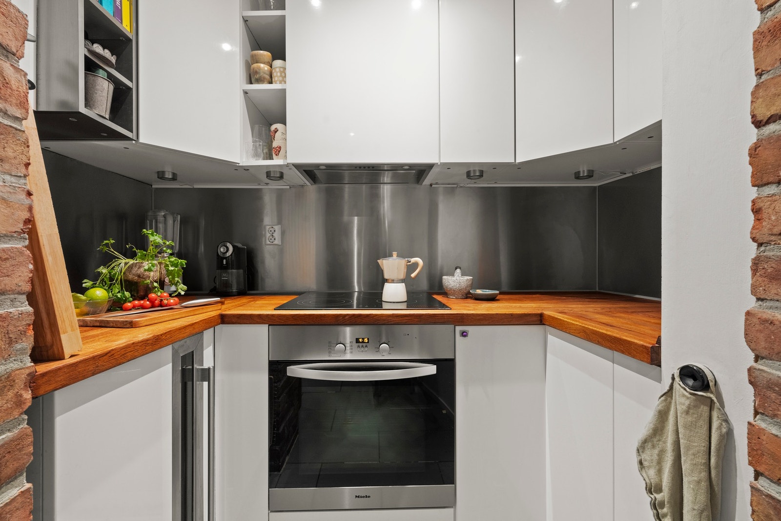 Praktisk og funksjonelt kjøkken med gode arbeidsflater og rikelig med skap- og benkeplass. Kjøkkenet er utstyrt med komfyr med koketopp og oppvaskmaskin Galleribilde