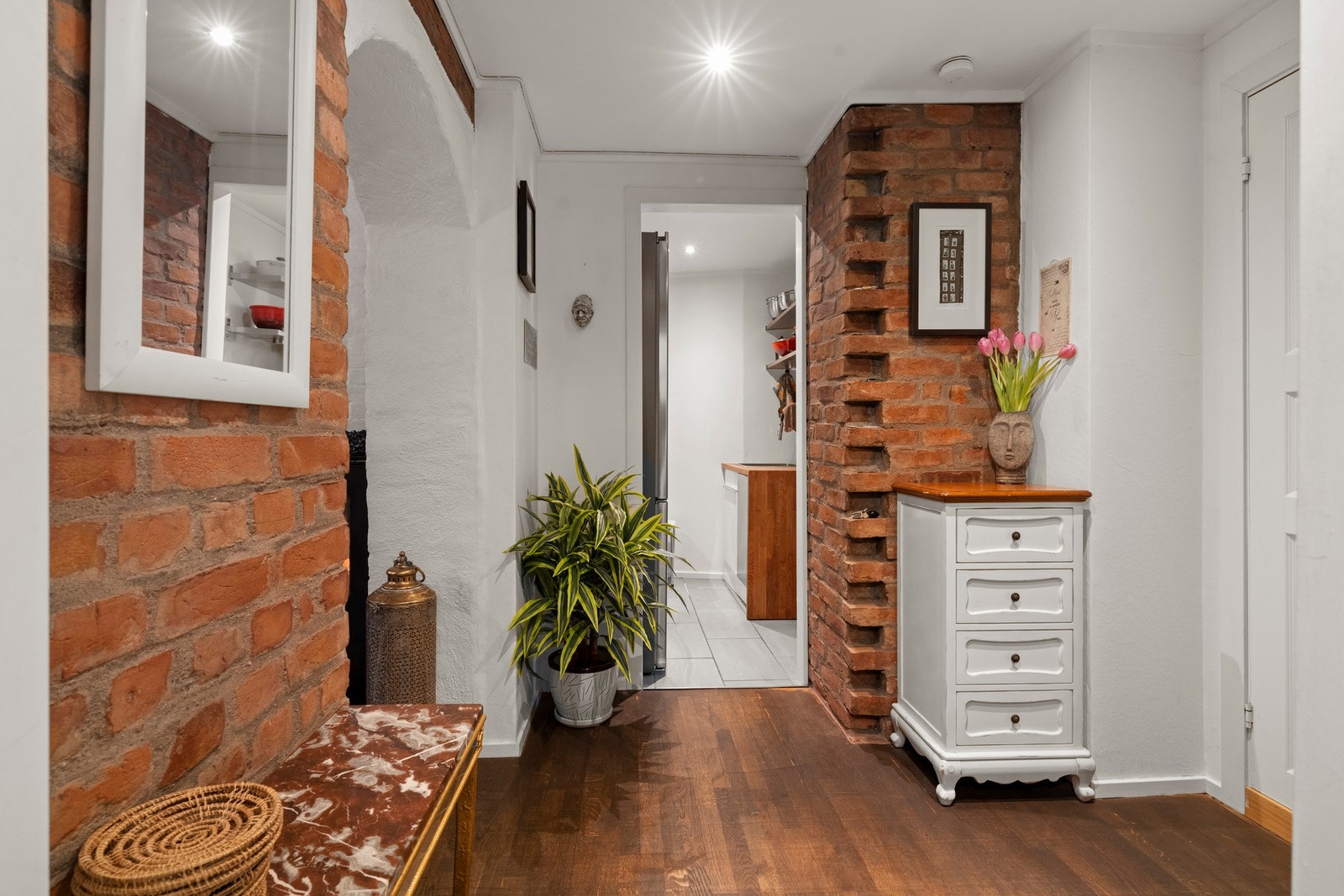 Velkommen inn! Leiligheten har en romslig og innbydende entré, den dekorative teglsteinsveggen skaper en lun atmosfære allerede ved første steg inn Galleribilde