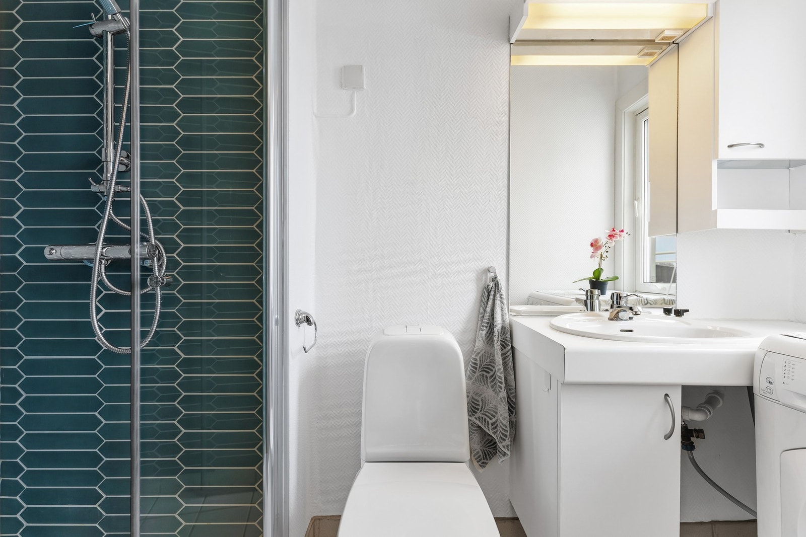 Badet har flislagt gulv og dekorative fargevalg i dusjsonen. Galleribilde