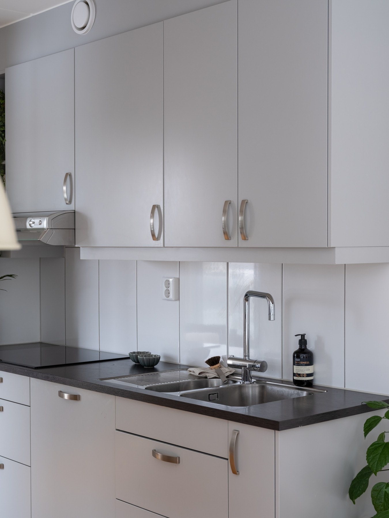 Grå innredning med slette fronter, laminat benkeplate og nedfelt oppvaskkum med ett-greps armatur. Galleribilde