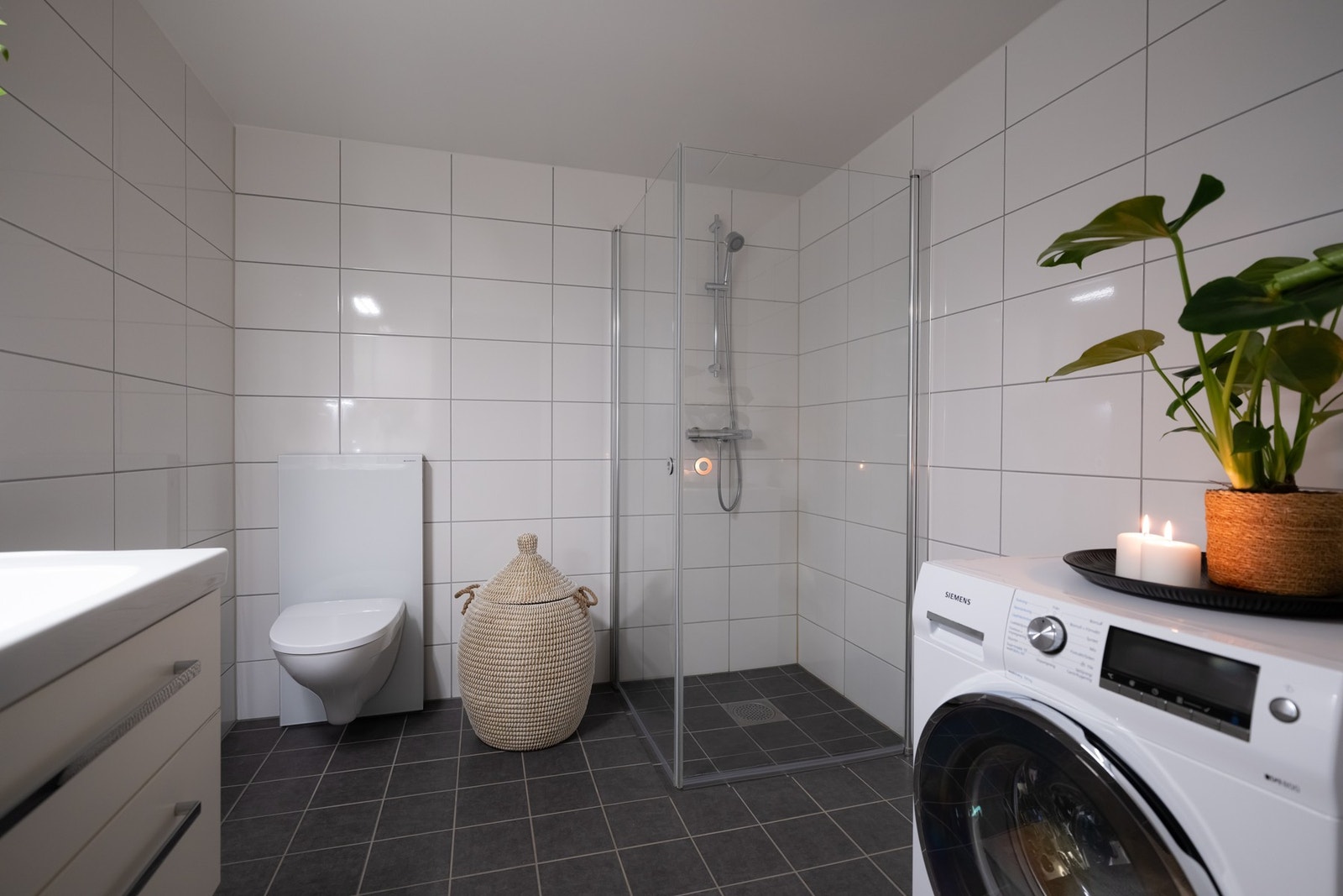 Det største baderommet er også boligens vaskerom med opplegg for vaskemaskin og plass til tørketrommel. Galleribilde