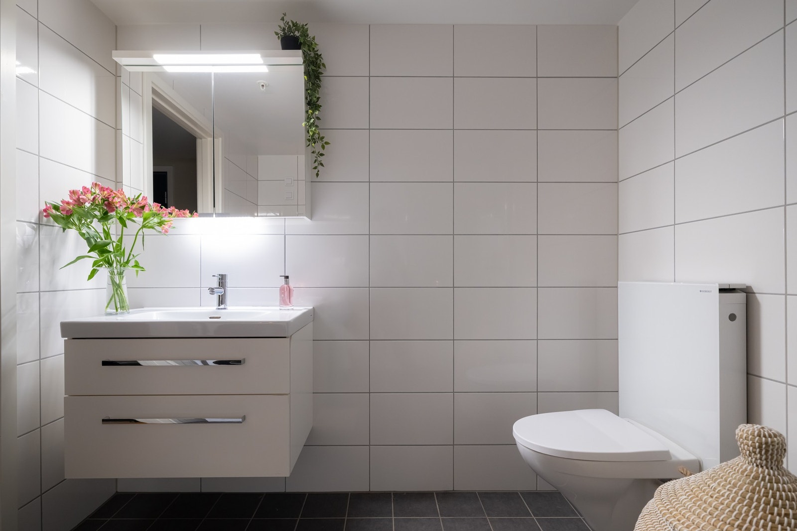 Baderomsinnredning med speilskap, vegghengt toalett og dusjhjørne. Galleribilde