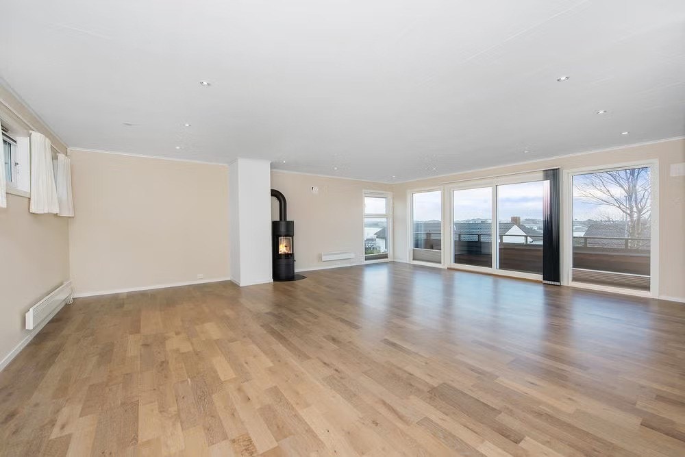 Romslig og lys stue med peisovn. Galleribilde