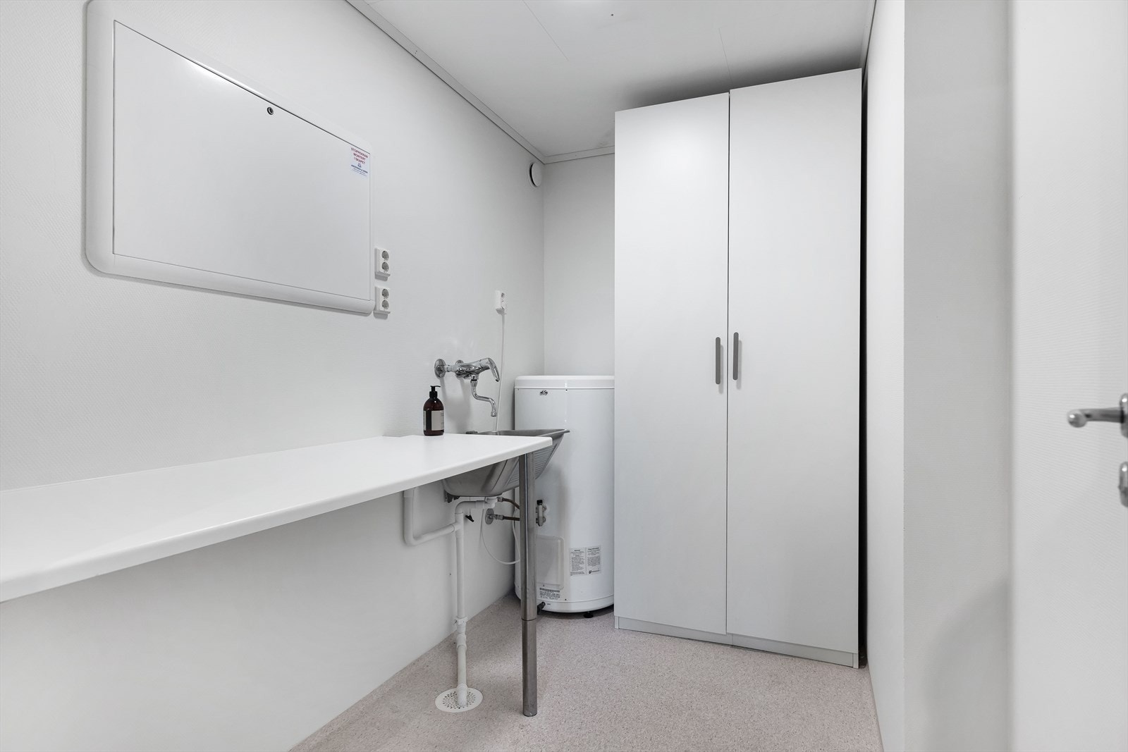 Praktisk vaskerom med opplegg for vaskemaskin og kondens tørketrommel, arbeidsbenk og stort garderobeskap. Galleribilde
