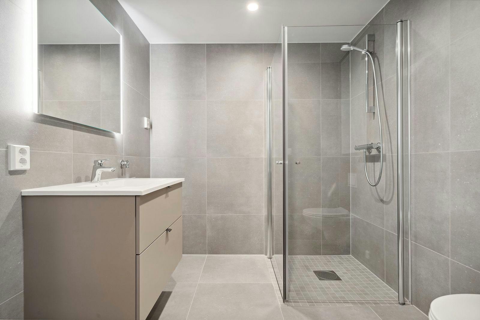 Flislagt baderom med gulvvarme og opplegg til vaskemaskin. Galleribilde