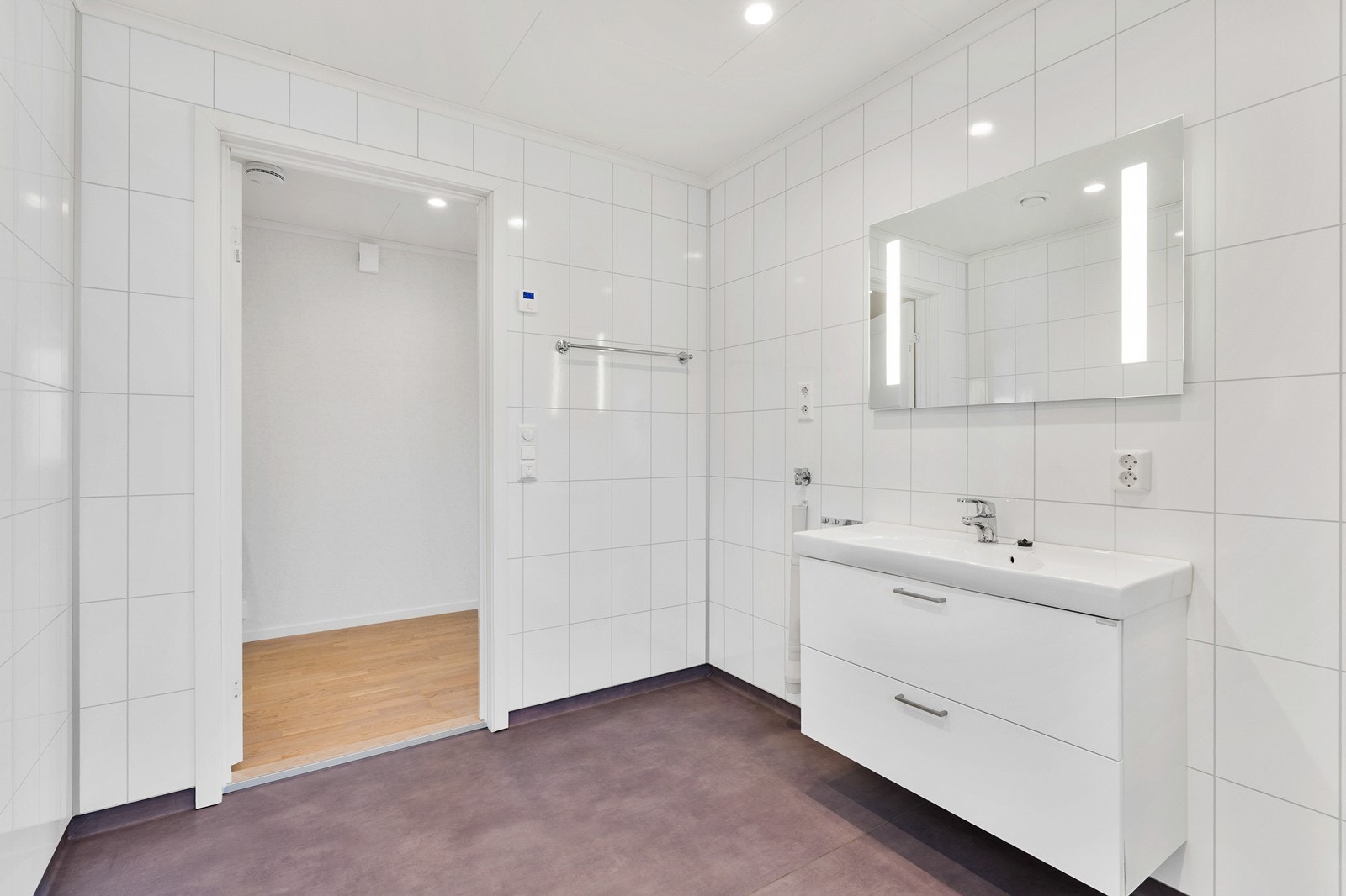 Badet er innredet med dusjkabinett, vegghengt toalett og baderomsinnredning med skuffer og speil. Galleribilde