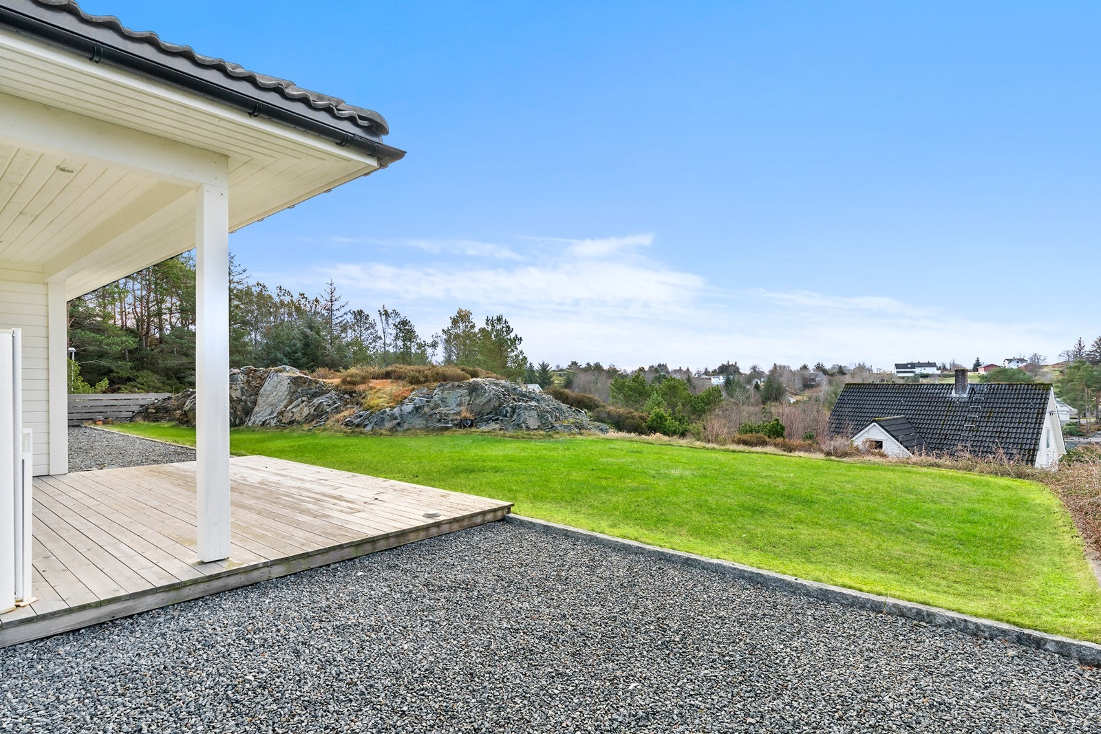 Tomten er praktisk og pent opparbeidet med asfalterte og gruslagte arealer for kjøring og parkering. Det er også støpt plate i carport, plen, treterrasse og elles naturtomt. Galleribilde