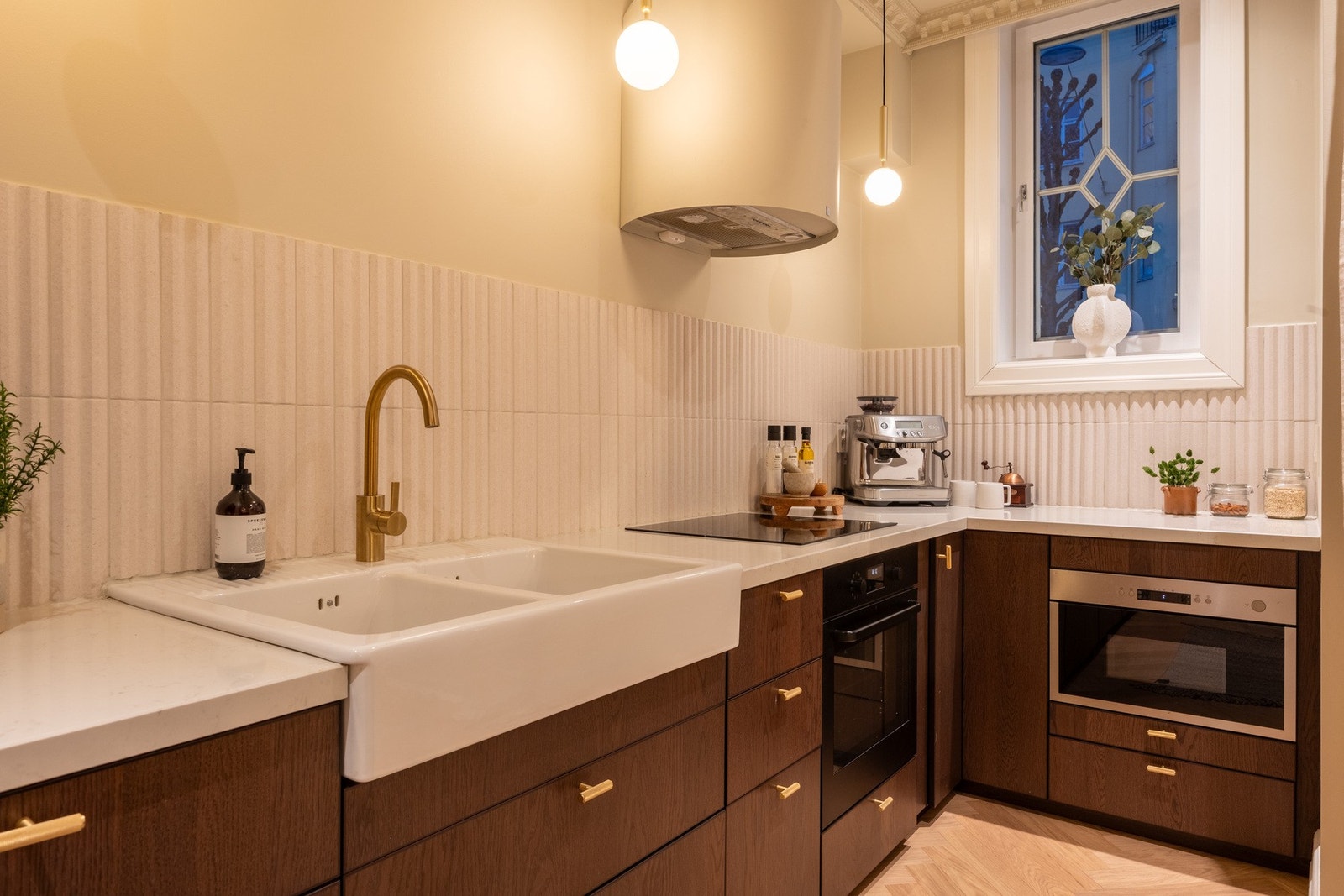 Det er benkeplater av kompositt med nedfelt oppvaskkum i hvit porselen og ett-greps vannkran. Galleribilde