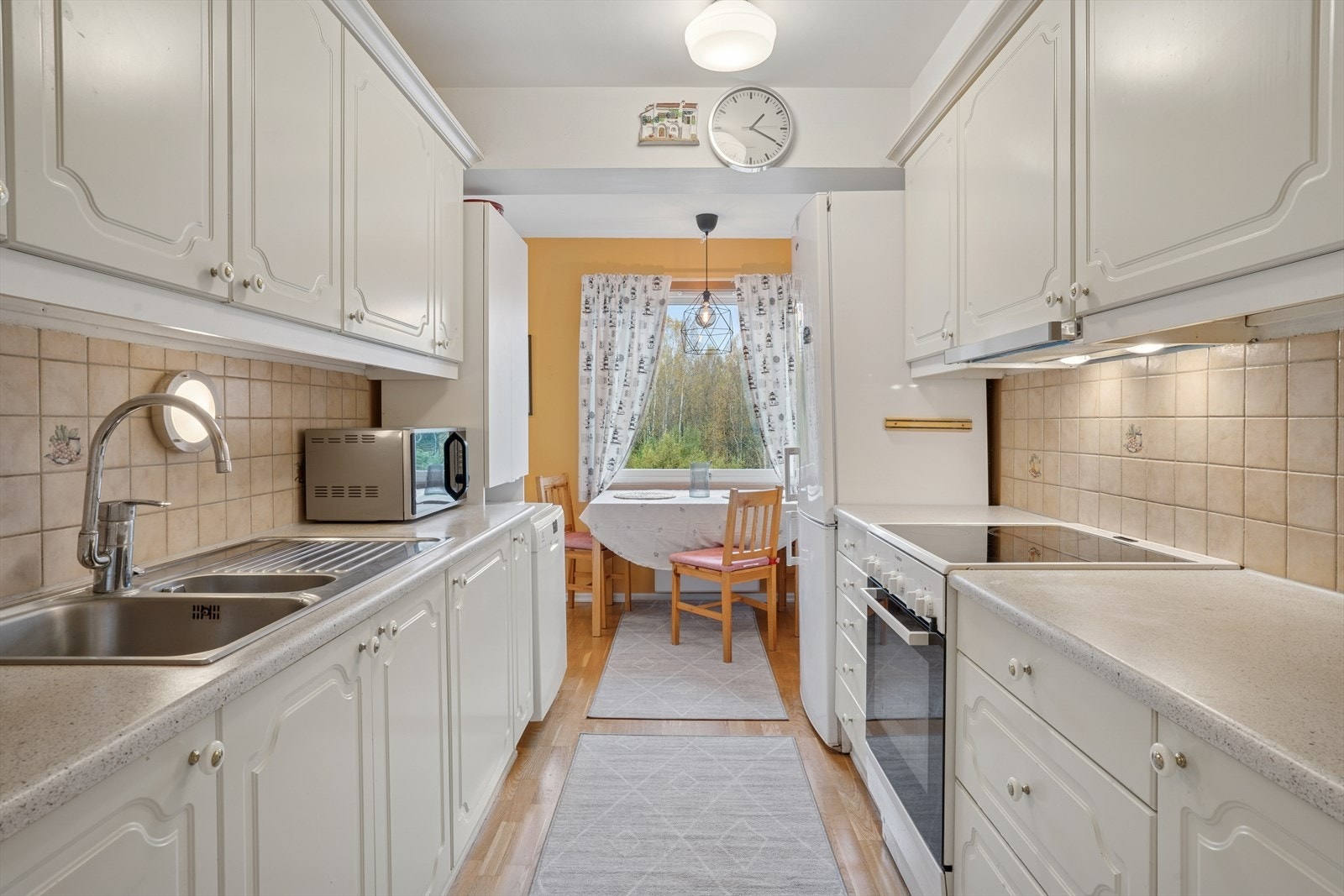 Pent kjøkken med hvite profilerte fronter. Galleribilde