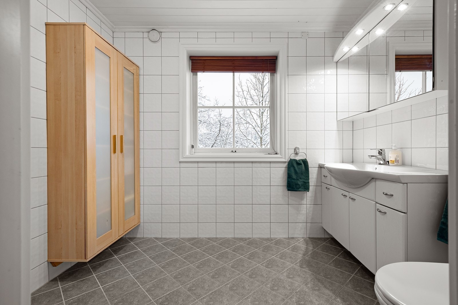 Bad i 2. etasje med fliser på gulv og vegger, samt malt himling Galleribilde