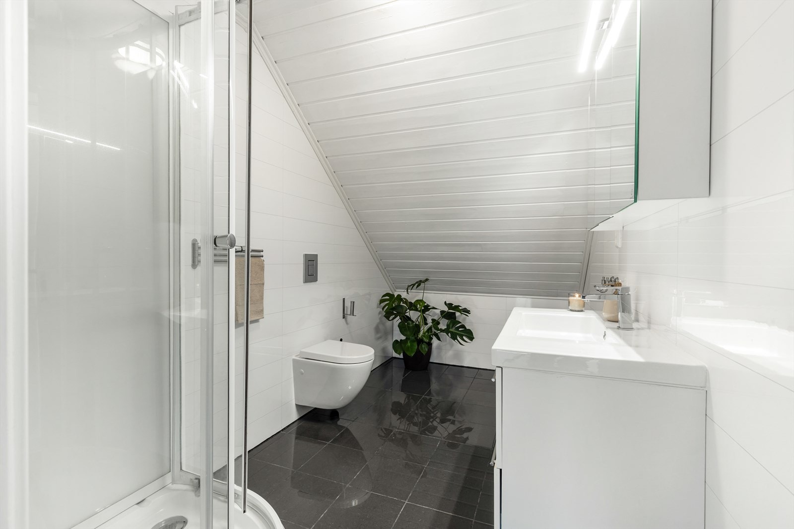 Det er fliser med gulvvarme, baderomsplater på vegg og panel i himling. Galleribilde