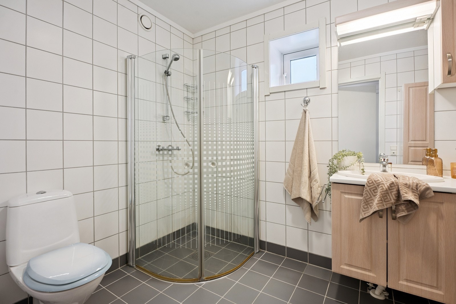 Blant annet har badet flislagt gulv og vegger, moderne møblemang og opplegg for vaskemaskin. Galleribilde