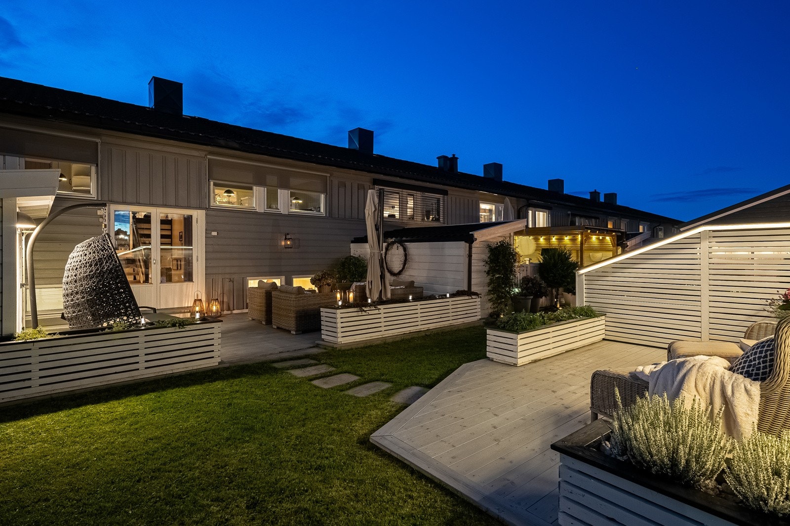 Rekkehusets uteområder er pent opparbeidet med gode soner for både lek, avslapning og sosialt samvær. Galleribilde