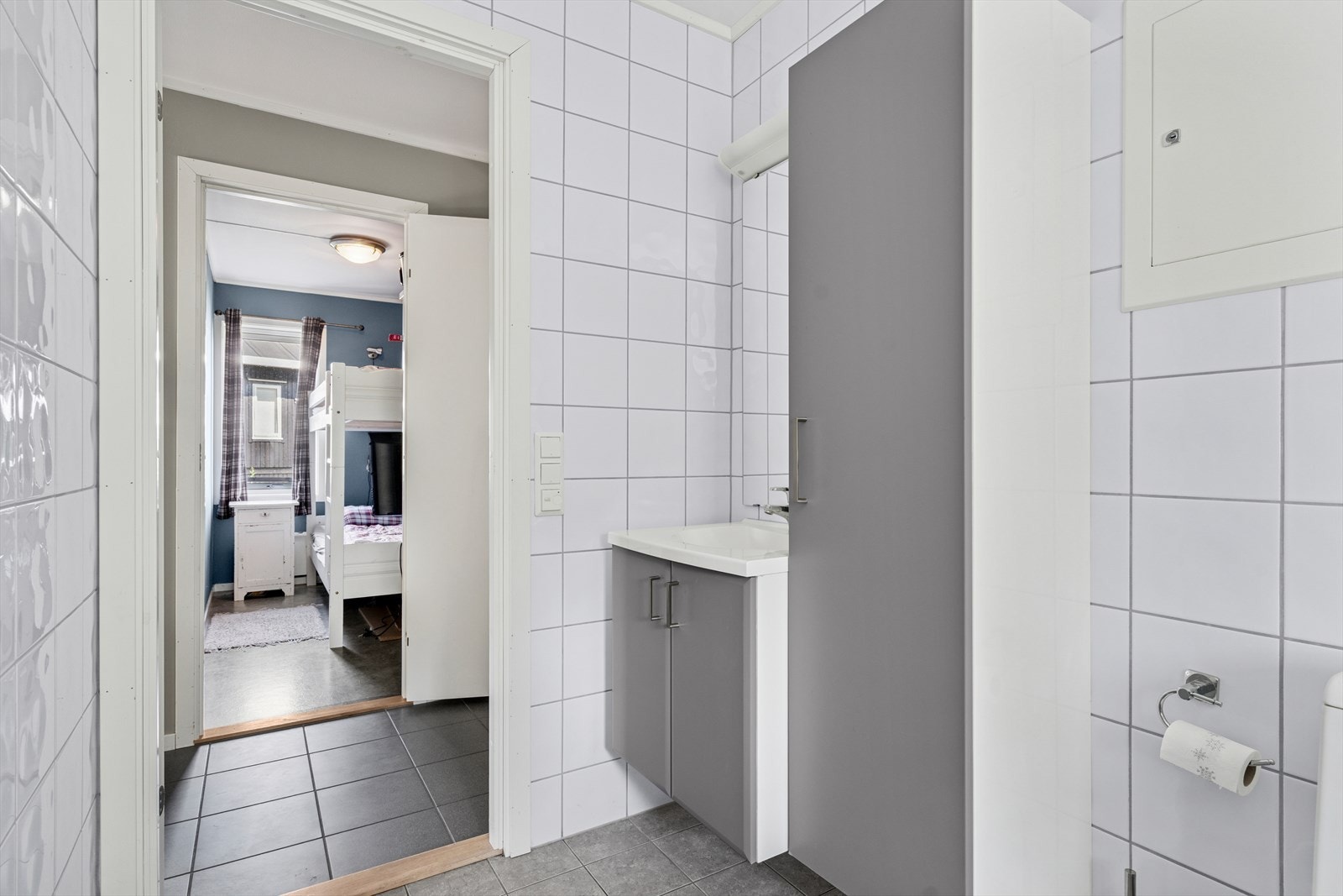 Badet har grå gulvfliser med behagelige varmekabler under og hvite veggfliser Galleribilde