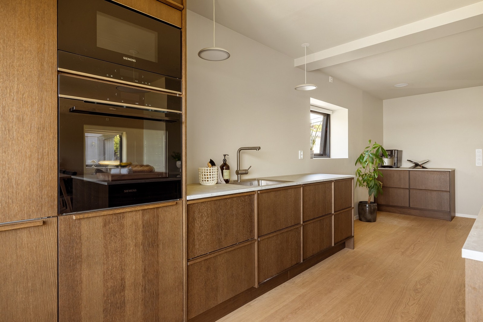 Kjøkkeninnredningen består av slette fronter i kombinasjon med benkeplate i laminat med underlimt vask av stål. Galleribilde