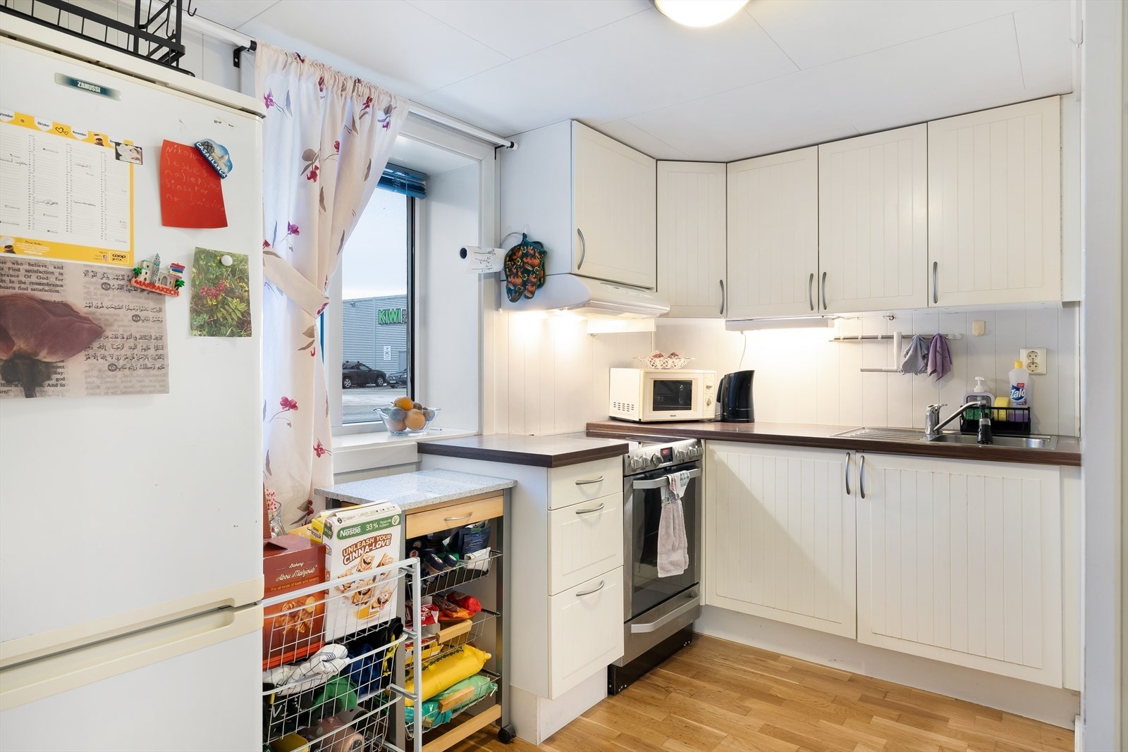 Kjeller - Kjøkkeninnredning fra IKEA med lyse profilerte fronter i over- og underskap, samt laminert benkeplate med oppvaskkum i stål med rillefelt. Galleribilde