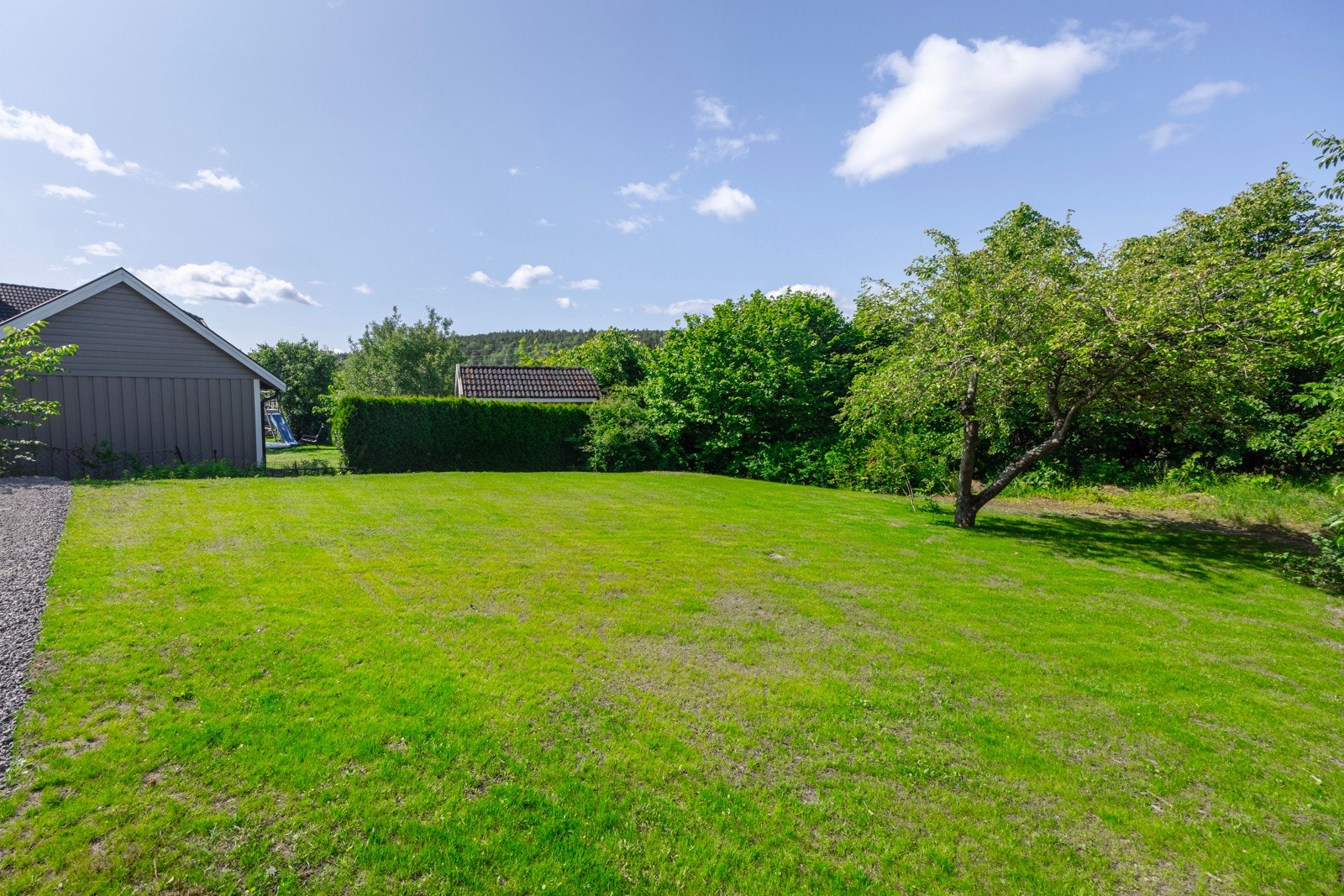 Tomten er pent opparbeidet med plenarealer og gruset gårdsplass. Den har gode solforhold og rikelig med plass til lek og moro - et ideelt uteområde for både små og store. Galleribilde