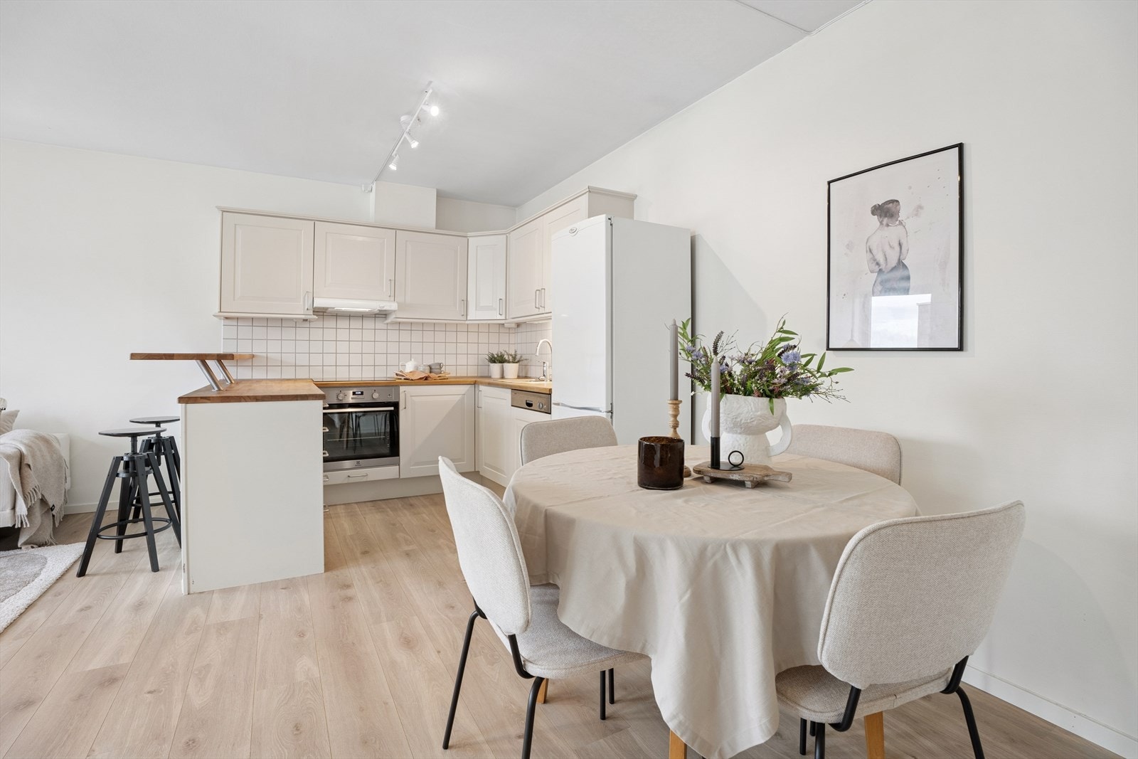 Lys og innbydende kjøkken med profilerte fronter og en solid benkeplate i heltre med nedfelt kum. Galleribilde