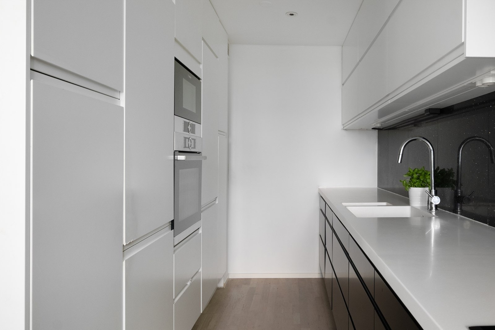 Granitt og fliser mellom benk og overskap gir et rent og elegant uttrykk. Galleribilde