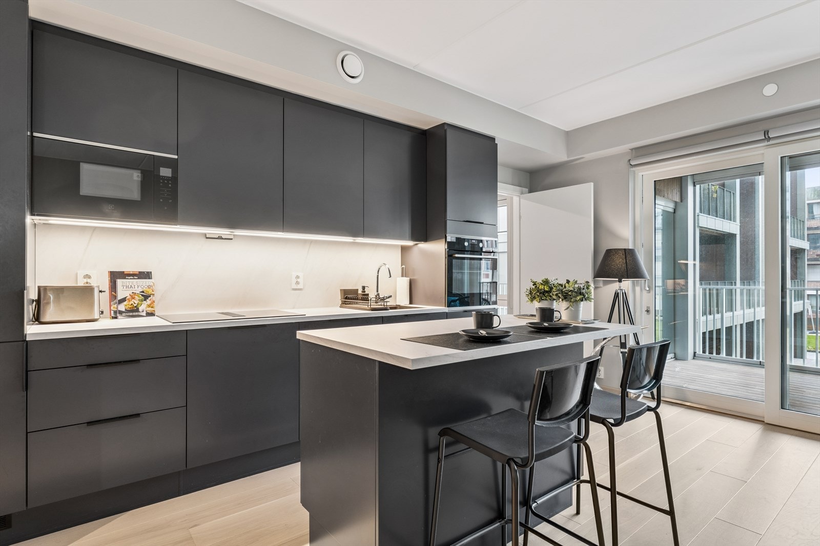 Leiligheten har en åpen og sosial planløsning mellom stue og kjøkken, med direkte utgang til balkong. Galleribilde