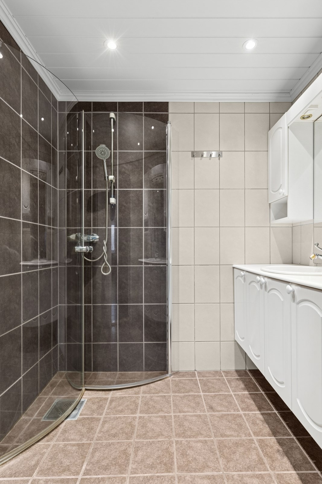 Badet har flislagt gulv med varmekabler og flislagte vegger. Innfelte LED downlights i himling. Galleribilde