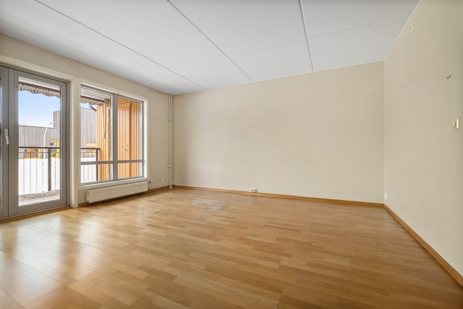 Stuen oppleves både lys og luftig med store vindusflater og doble balkongdører, som skaper en god atmosfære i hele rommet Galleribilde