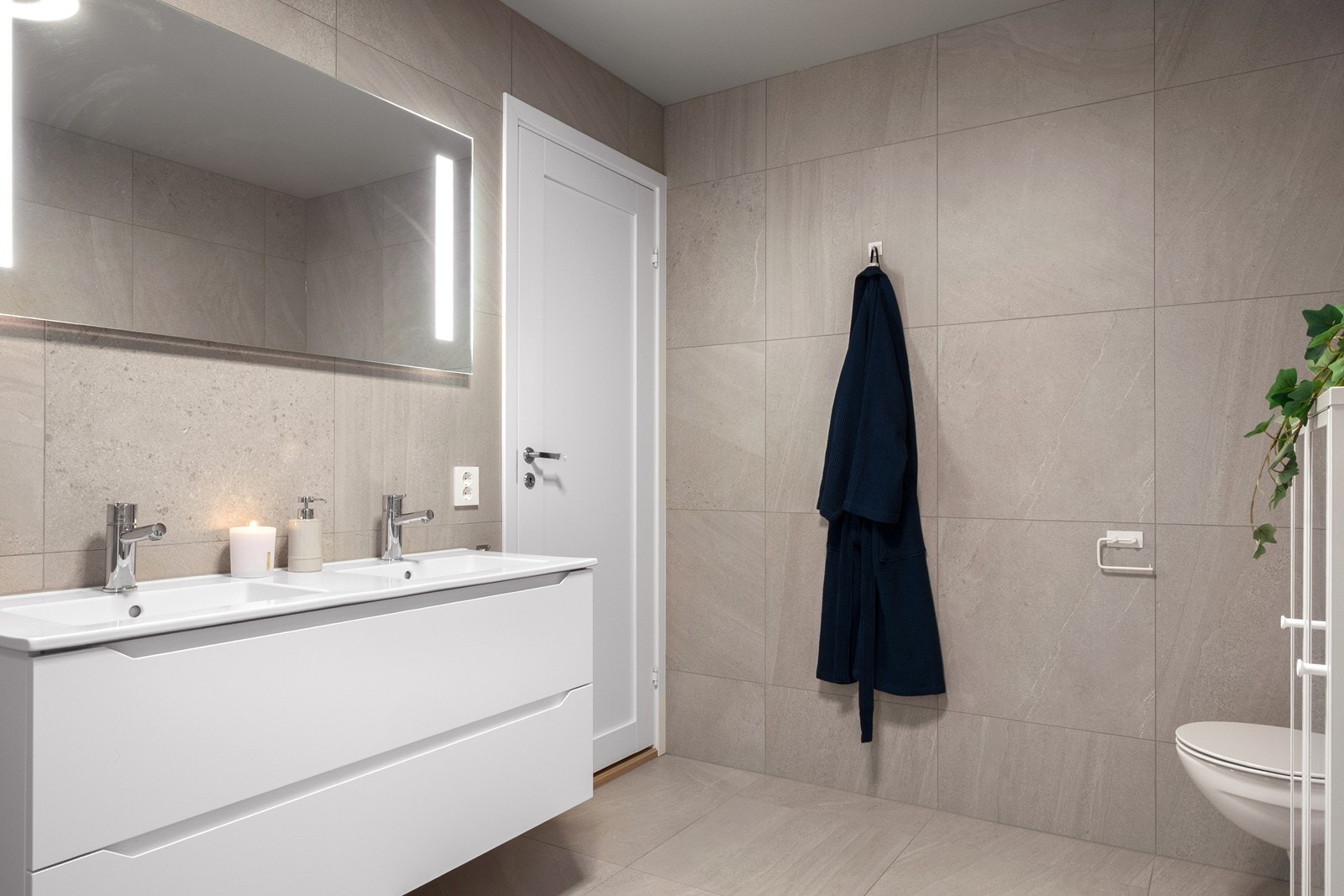 Hovedbadet har adkomst fra hovedsoverommet, er romslig og innredet med dobbeltservant med skuffeseksjon, speil med belysning, vegghengt toalett og håndkletørker. Galleribilde