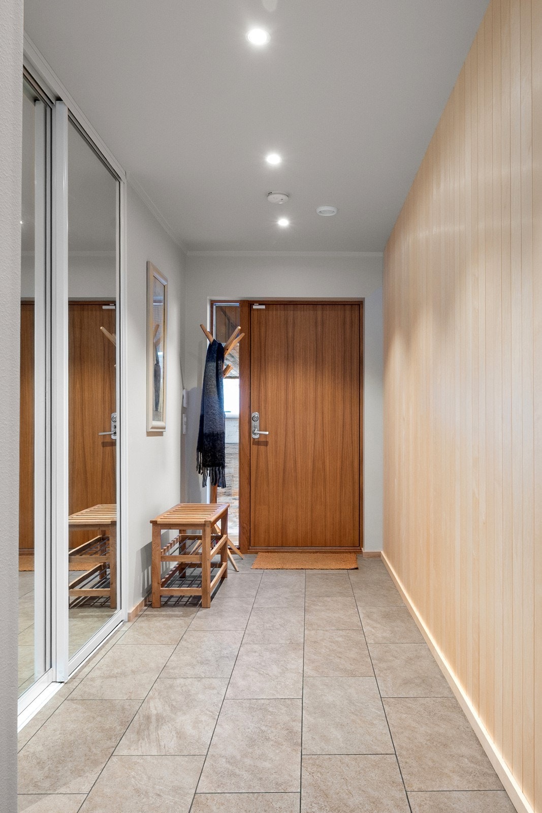 Vel innenfor møtes du av en romslig entré med flislagt gulv, behagelig gulvvarme og downlights i himling. Entréen er utstyrt med praktisk skyvedørsgarderobe som gir gode oppbevaringsløsninger. Galleribilde