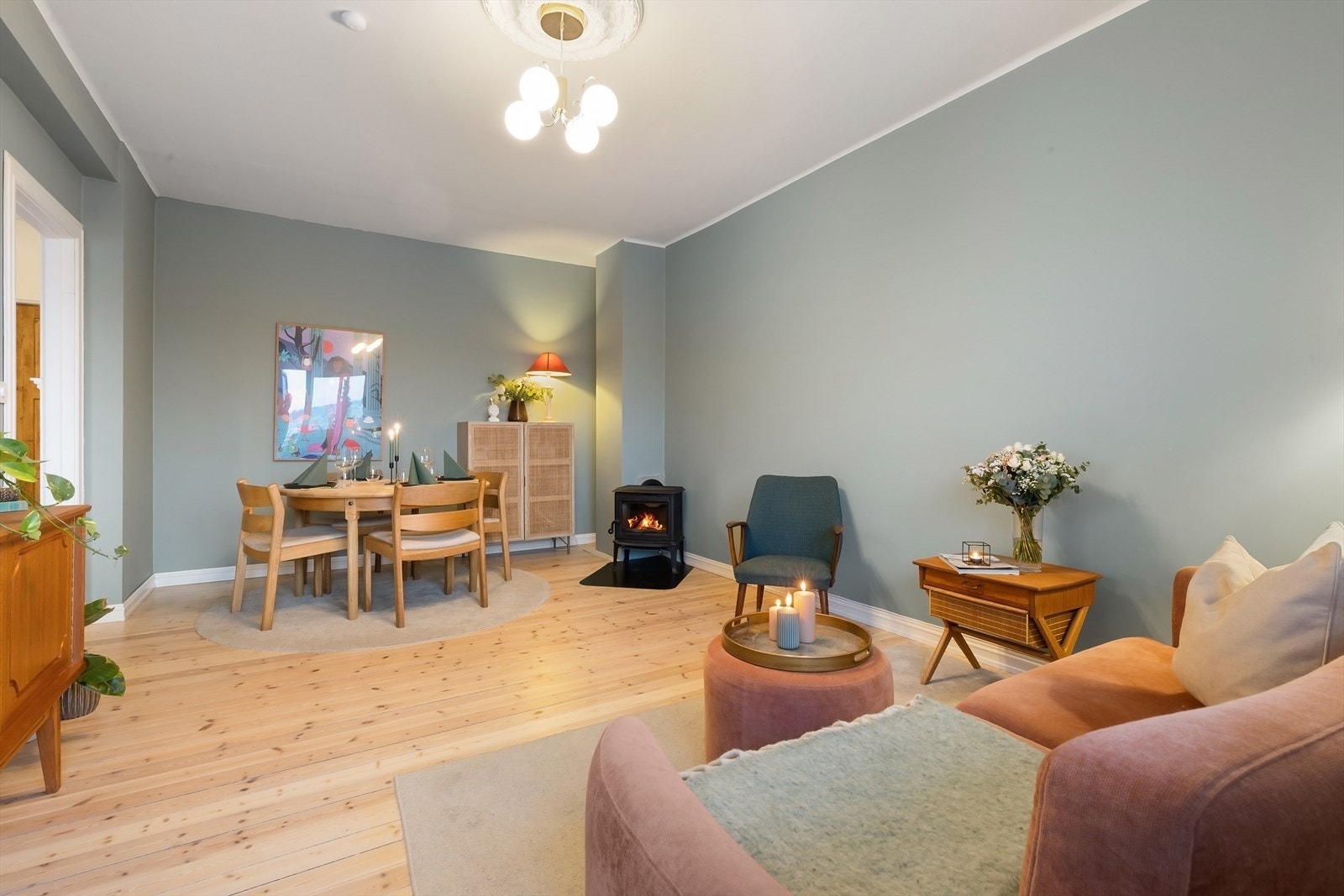 Stue med god plass til både sofa, mediemøblement og spisebord. Peisovnen gir en varm og hyggelig stemning, perfekt for avslapning og sosiale sammenkomster. Galleribilde