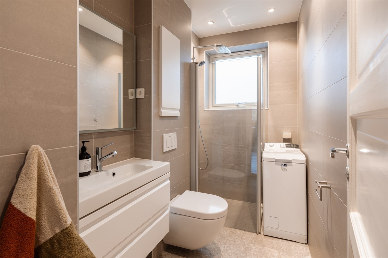 Badet er moderne flislagte overflater, behagelig gulvvarme og downlights i taket Galleribilde