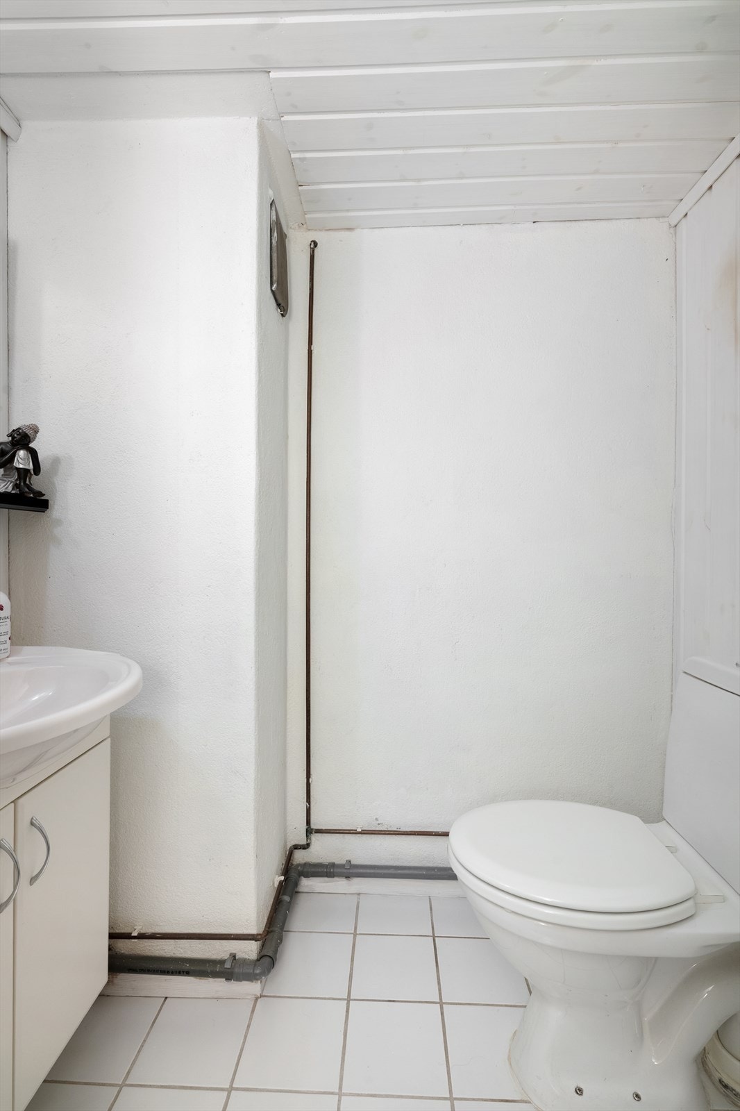 Toalettrommet innehar toalett og servantmøbel med skap og speil. Galleribilde