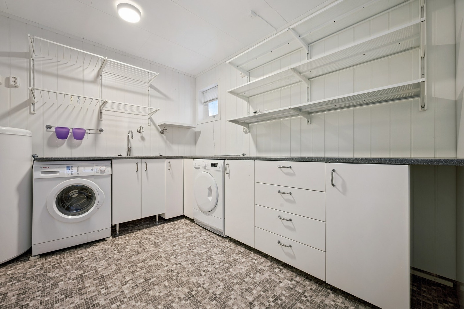 I tilknytning til badet ligger et separat vaskerom med plass til vaskemaskin, tørketrommel og oppbevaring. Galleribilde