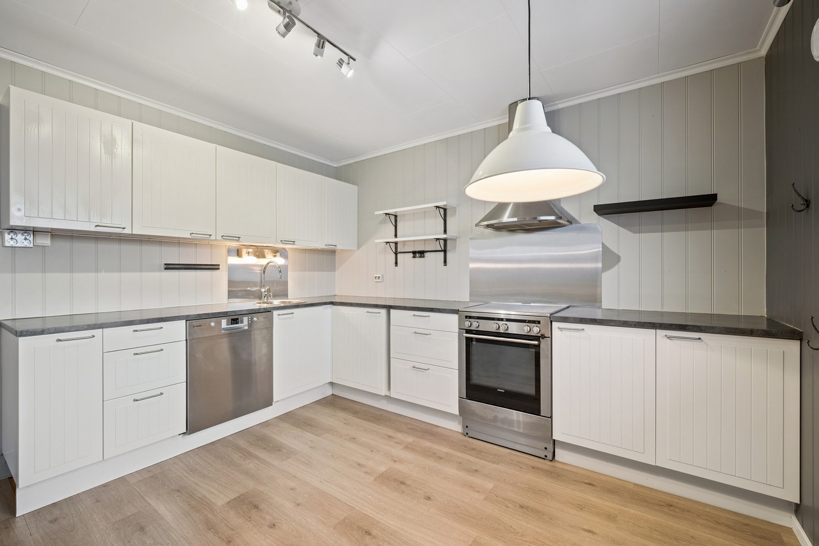 Kjøkkenet er integrert i oppholdsrommet og har funksjonell innredning med god skap- og benkeplass. Galleribilde