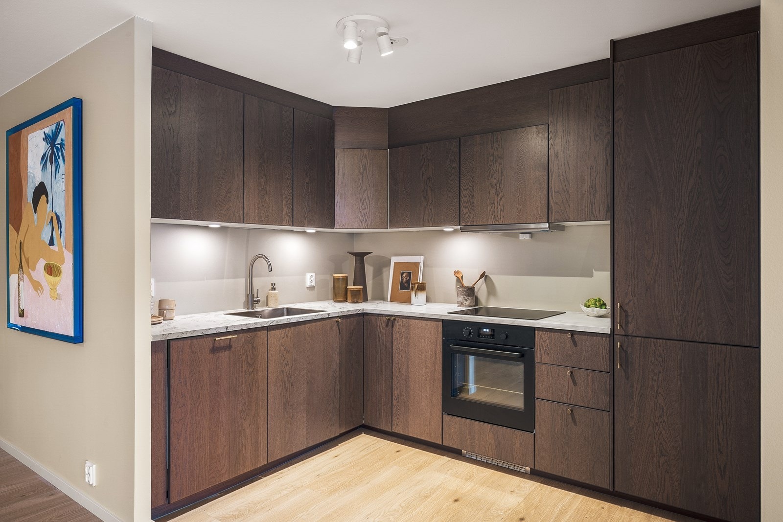 Kjøkkenet er pent avdelt fra stuen og lekkert utført i treutførelse med slette fronter. Galleribilde