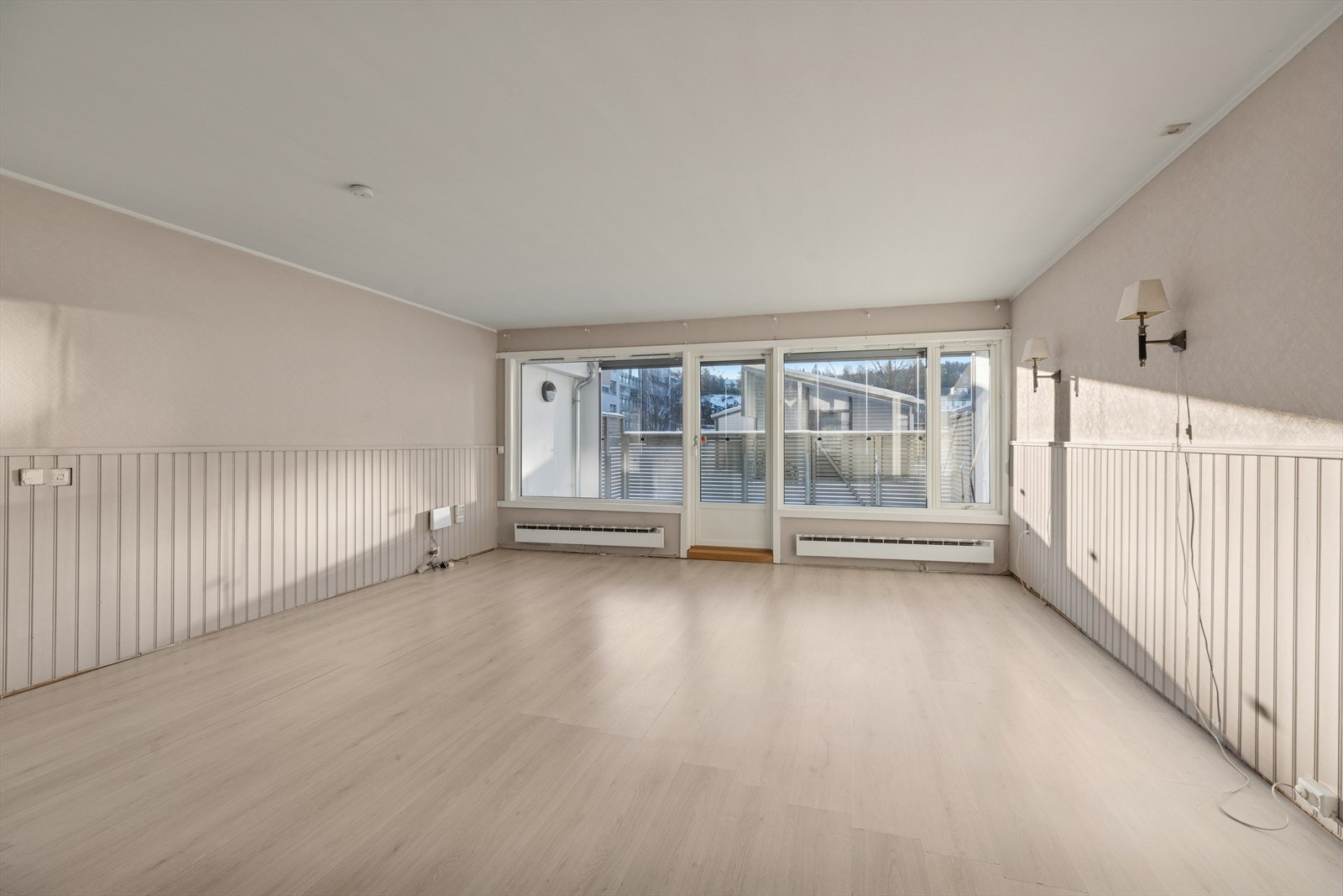 Store vindusflater og terrassedør sørger for godt med dagslys og skaper en åpen og luftig atmosfære Galleribilde