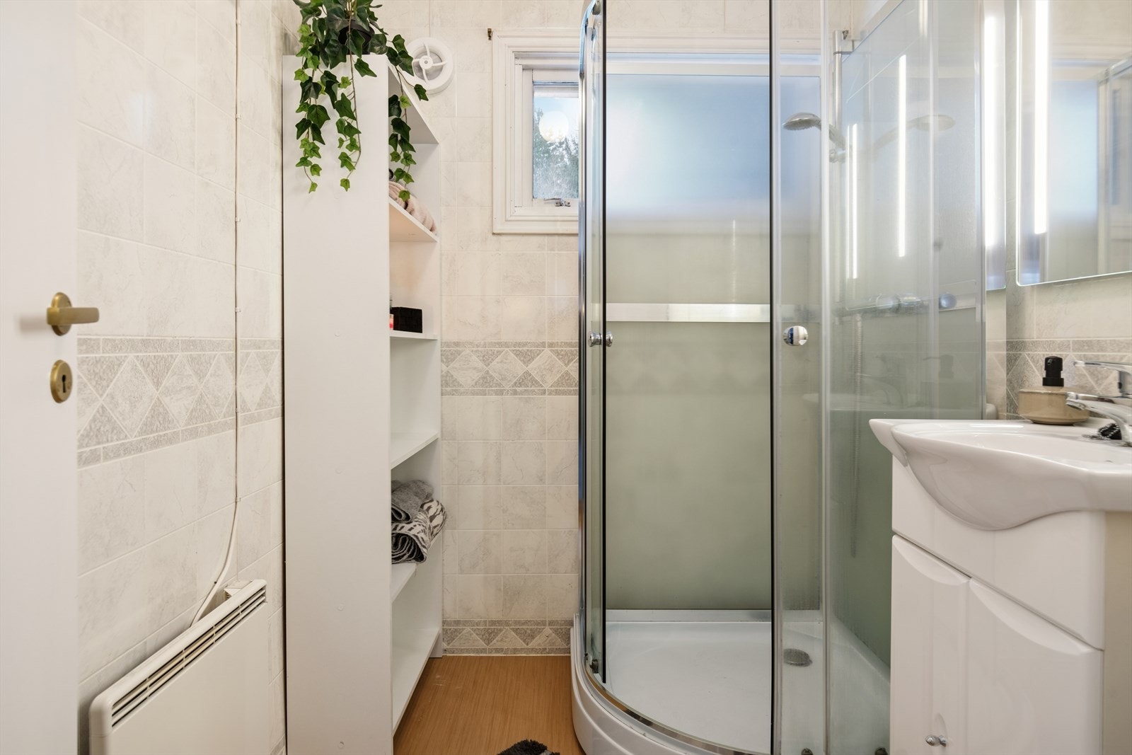 Eldre, men velfungerende baderom med nyere dusjkabinett. Galleribilde