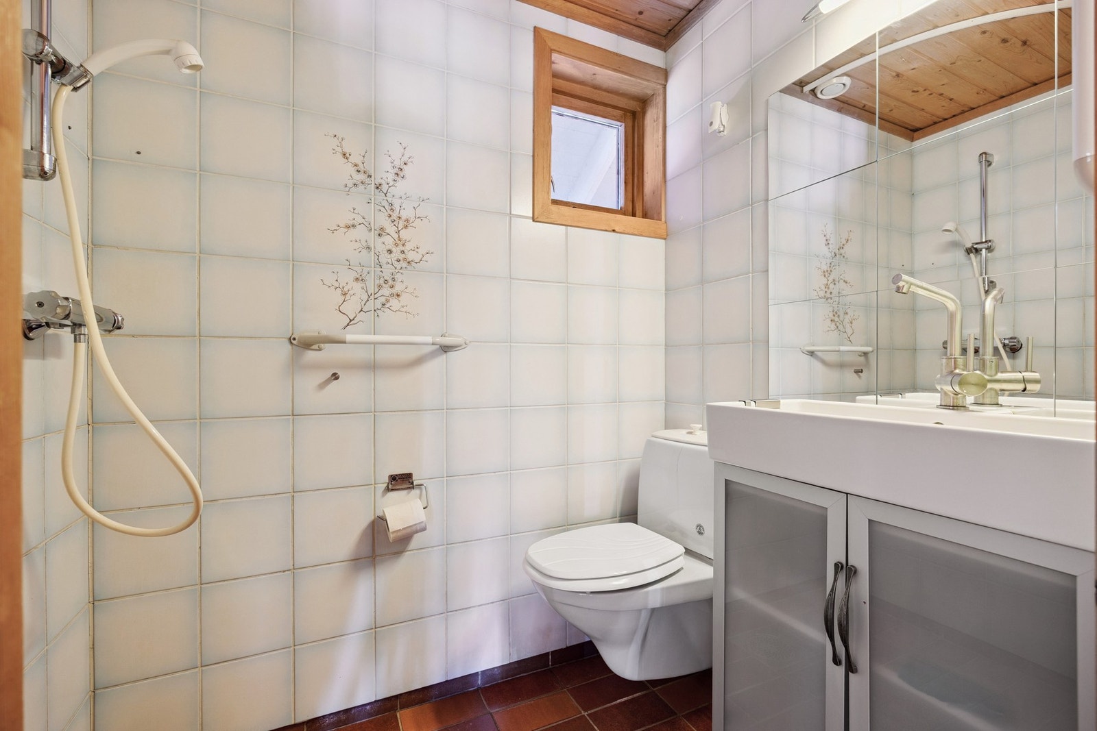 Rommet er utstyrt med dusjhjørne, vegghengt toalett, servantinnredning med ovenpåliggende servant og speil med overlys. Galleribilde