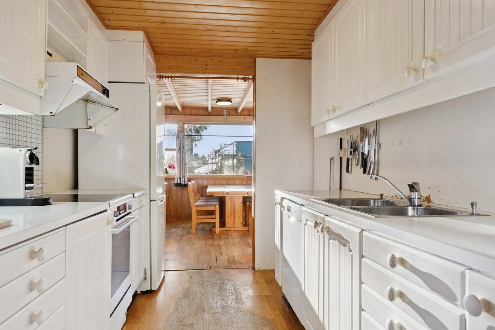 Kjøkkenet i 1. etasje har en åpen og sosial løsning mot stue, med innredning fra byggeår i profilerte fronter, laminat benkeplate, nedfelt oppvaskkum og gode arbeidsflater. Galleribilde