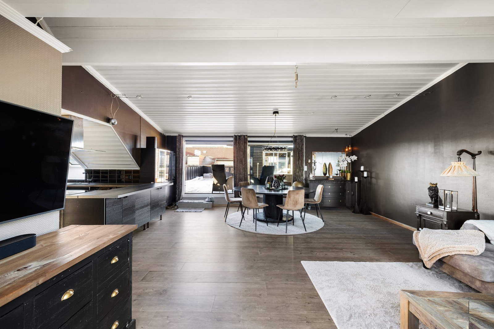 En stor og åpen gulvflate gjør stuen enkel å møblere. Sitteplass er det også langs kjøkkenets smarte barløsning. Galleribilde