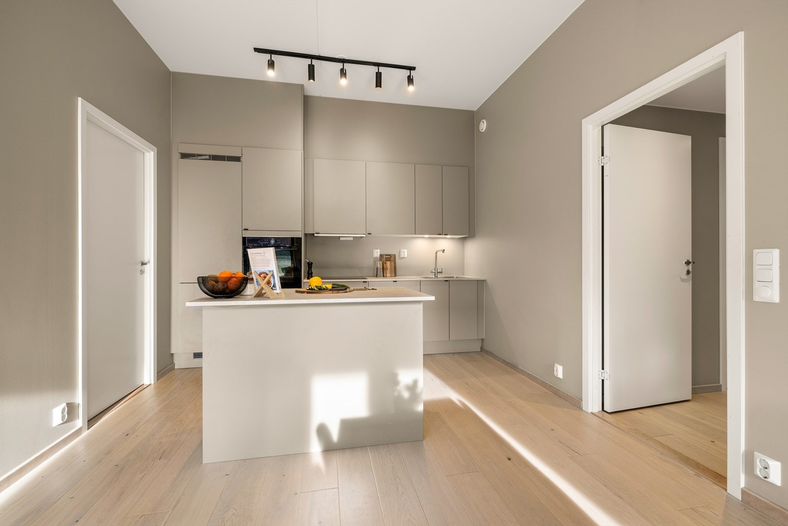 Kjøkkenøy som fungerer som en naturlig samlingsplass og gir ekstra arbeidsflate. Galleribilde