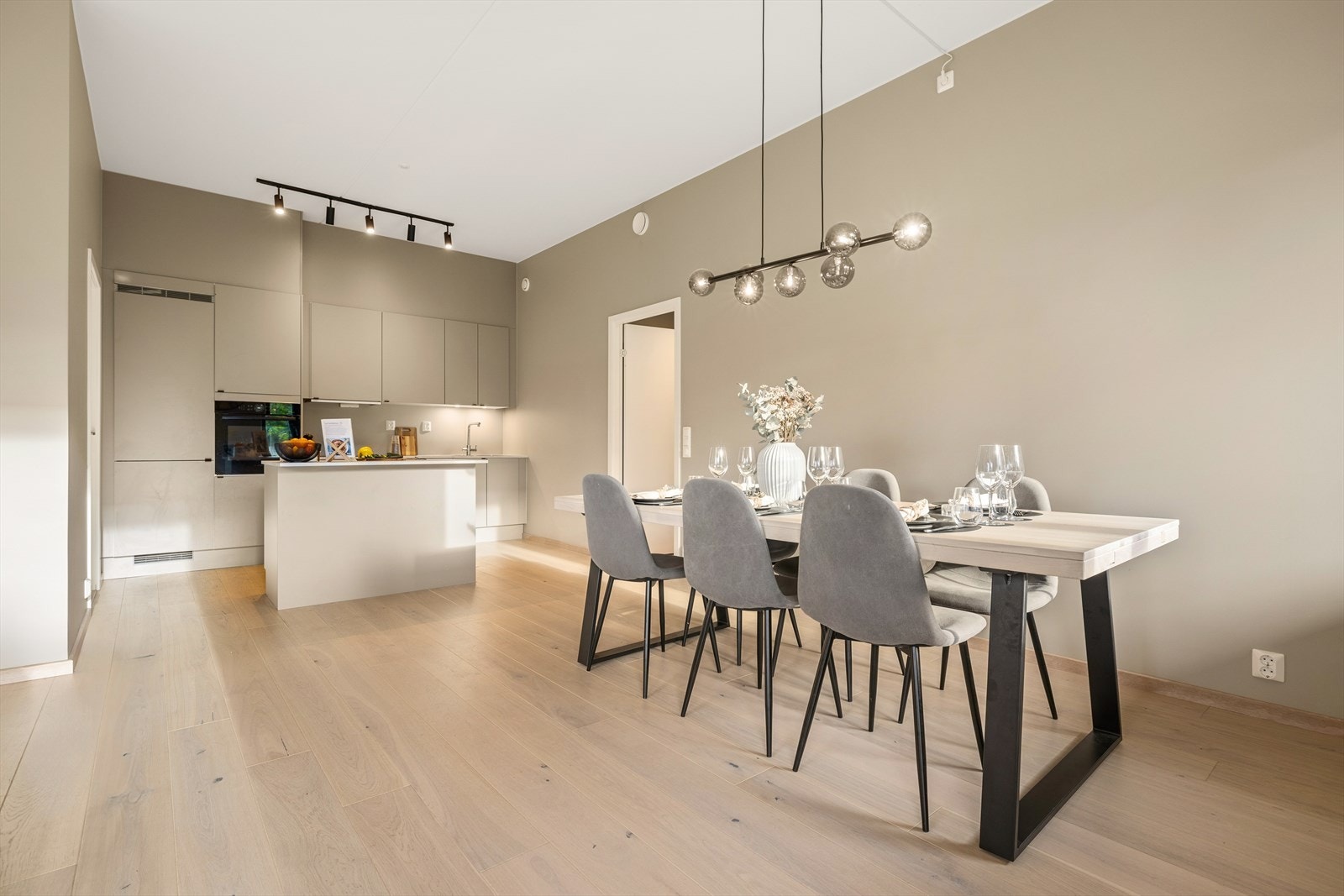 Spisestuen er plassert i elegant overgang til det stilrene kjøkkenet. Galleribilde