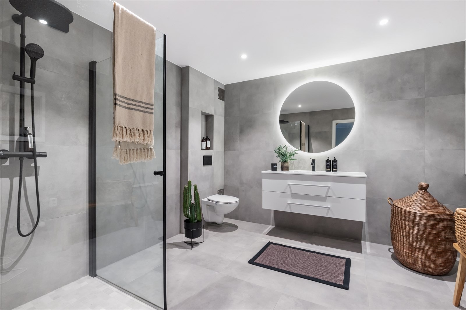 Rålekkert bad fra 2024 i underetasjen med moderne grå fliser på vegg og gulv med varme. Galleribilde