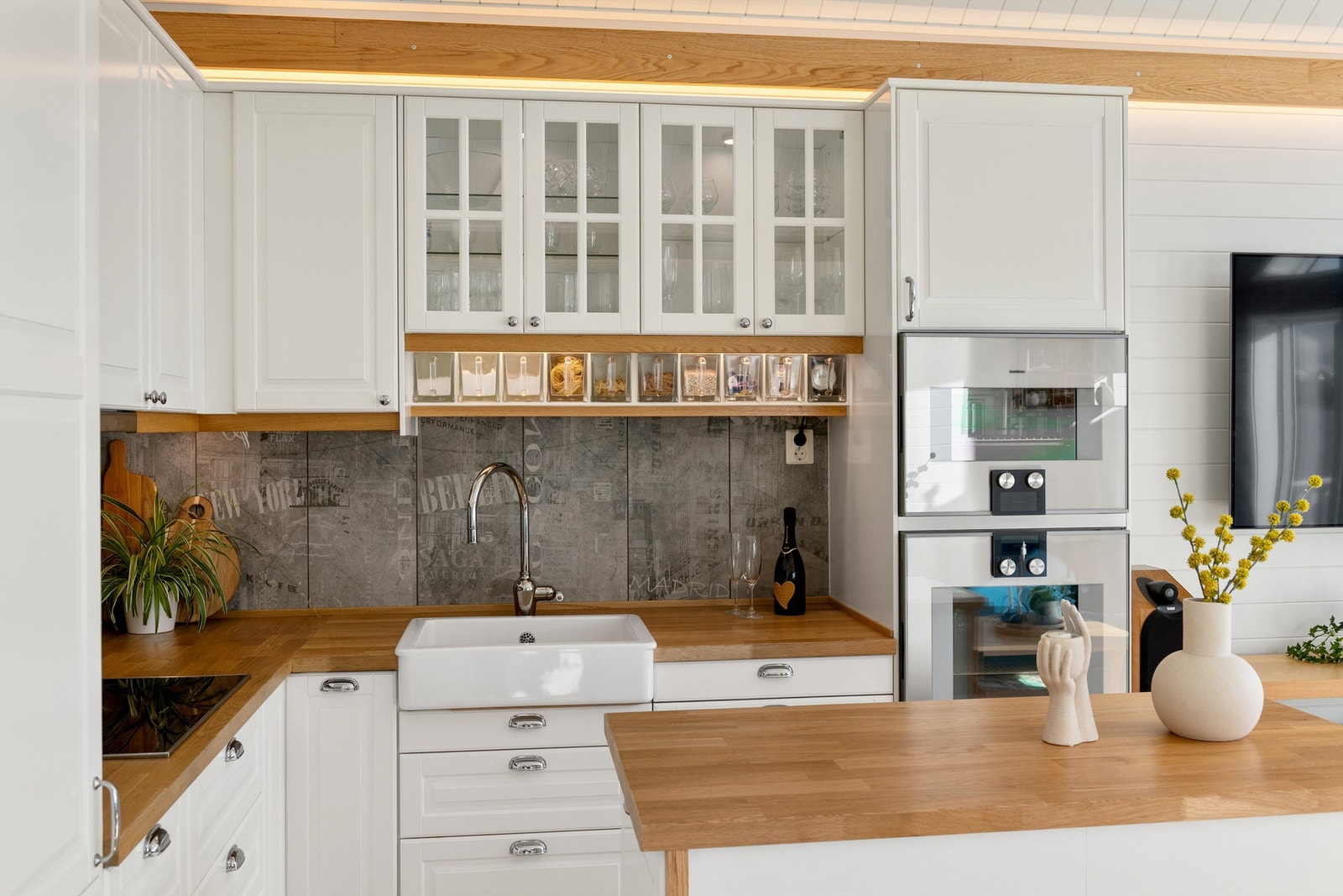 Gaggenau integrert stekeovn og dampovn, platetopp, oppvaskmaskin og kjøleskap med fryser. Ventilator i overskap med komfyrvakt. Det er lagt fliser mellom kjøkkenbenk og overskap. Galleribilde