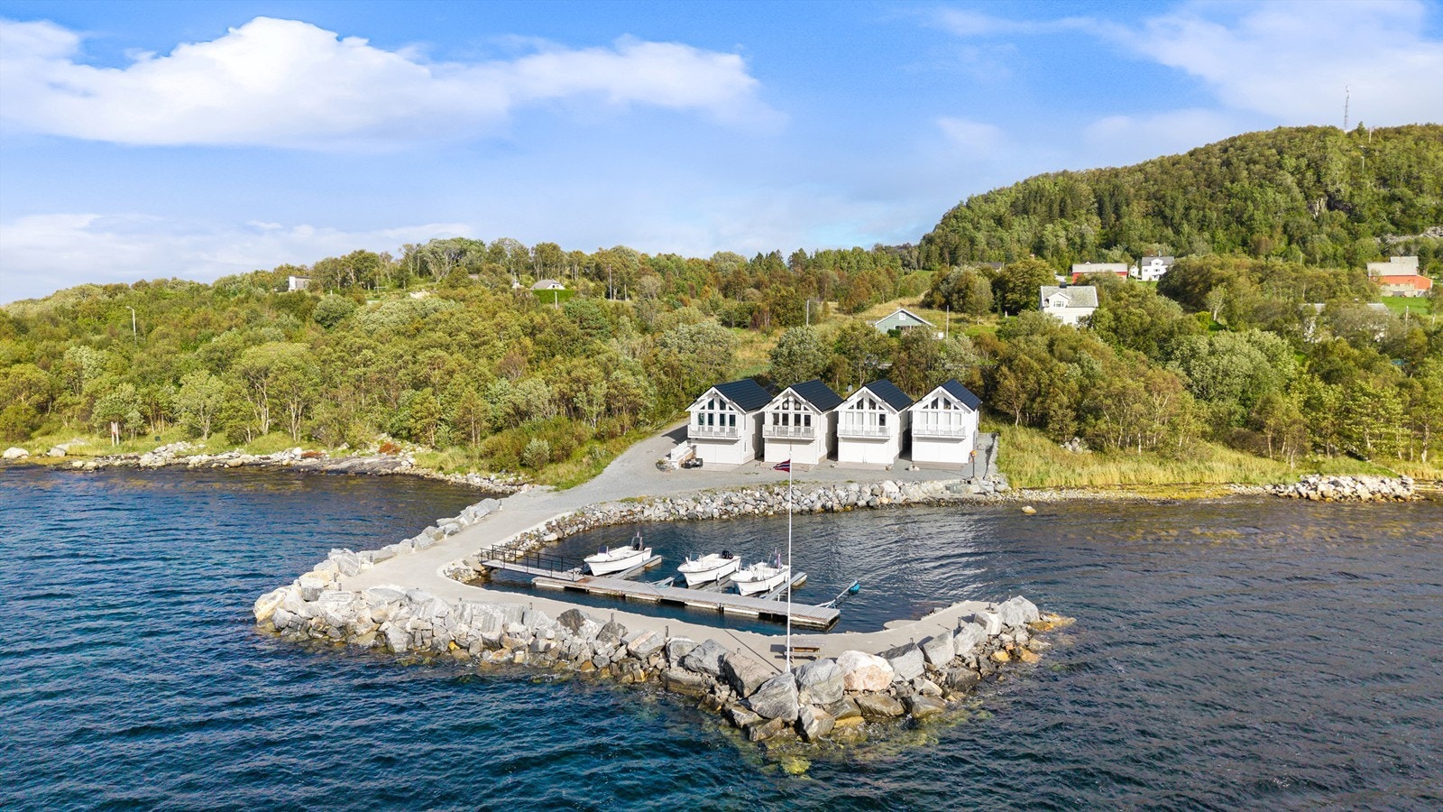 Dronebilde av rorbuene, molo og båthavna Galleribilde