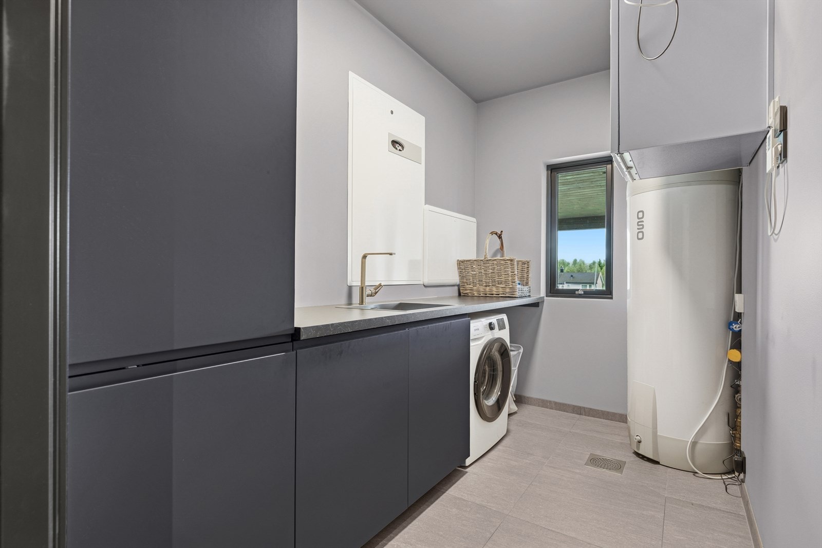 Eget separat vaskerom med sort, matt innredning. Galleribilde