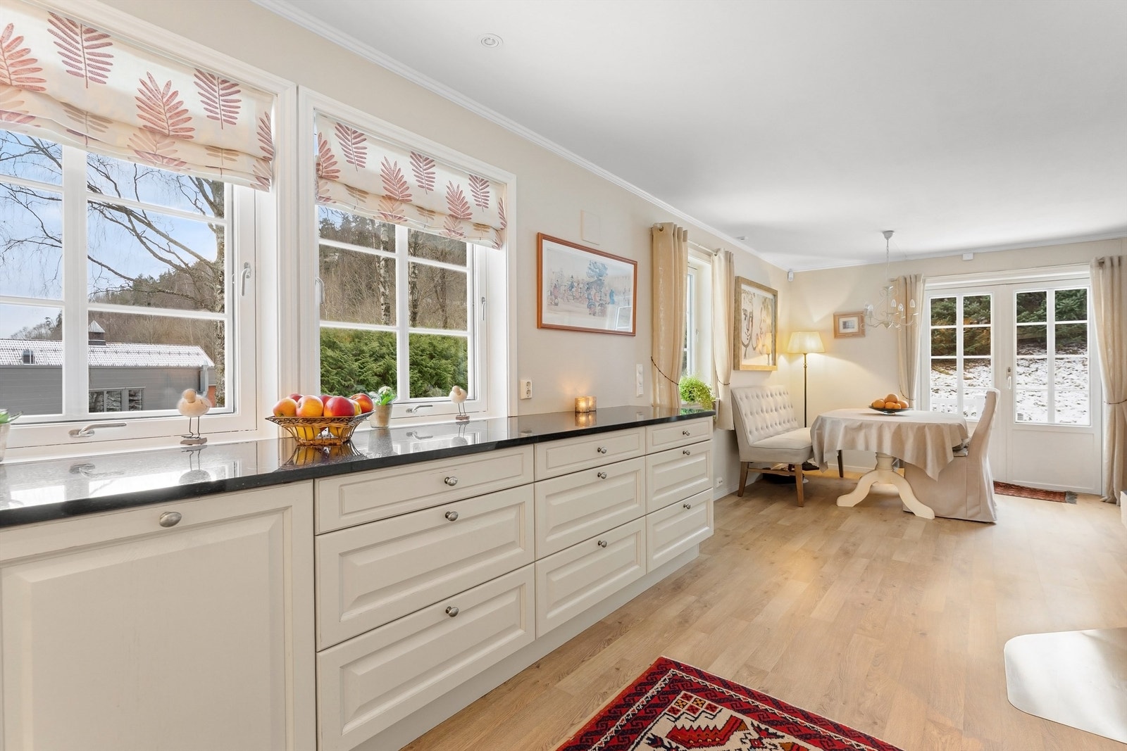 Kjøkkenet har profilerte fronter på skap og skuffer, og benkeplater i stein Galleribilde