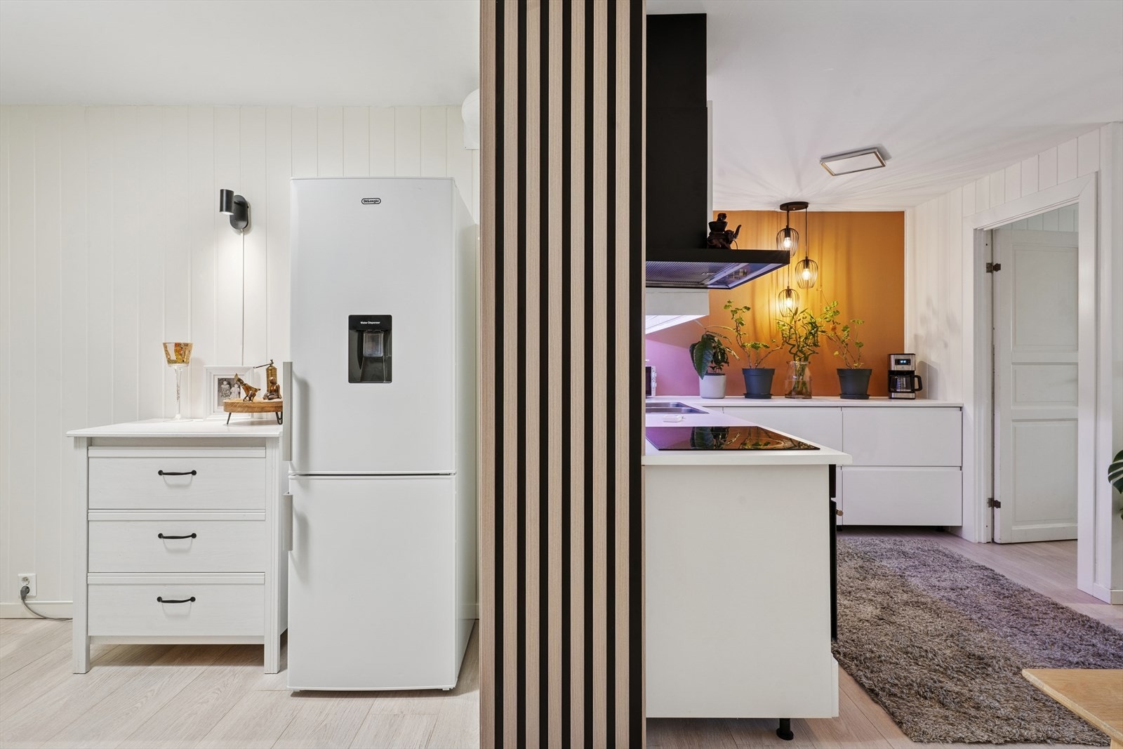 En spilevegg i tre skaper et stilrent og visuelt skille mot kjøkkenet. Galleribilde